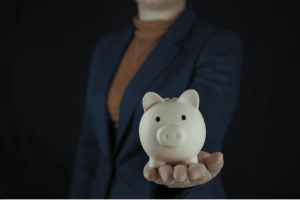 Entrepreneur en costume tenant une tirelire représentant l’épargne professionnelle