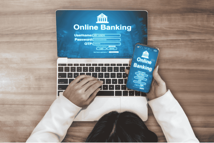 Personne accédant à une interface de banque en ligne via ordinateur portable et mobile