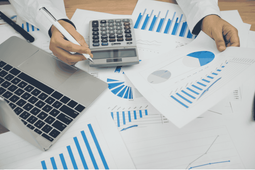 Documents financiers et graphiques de performance analysés sur un bureau professionnel